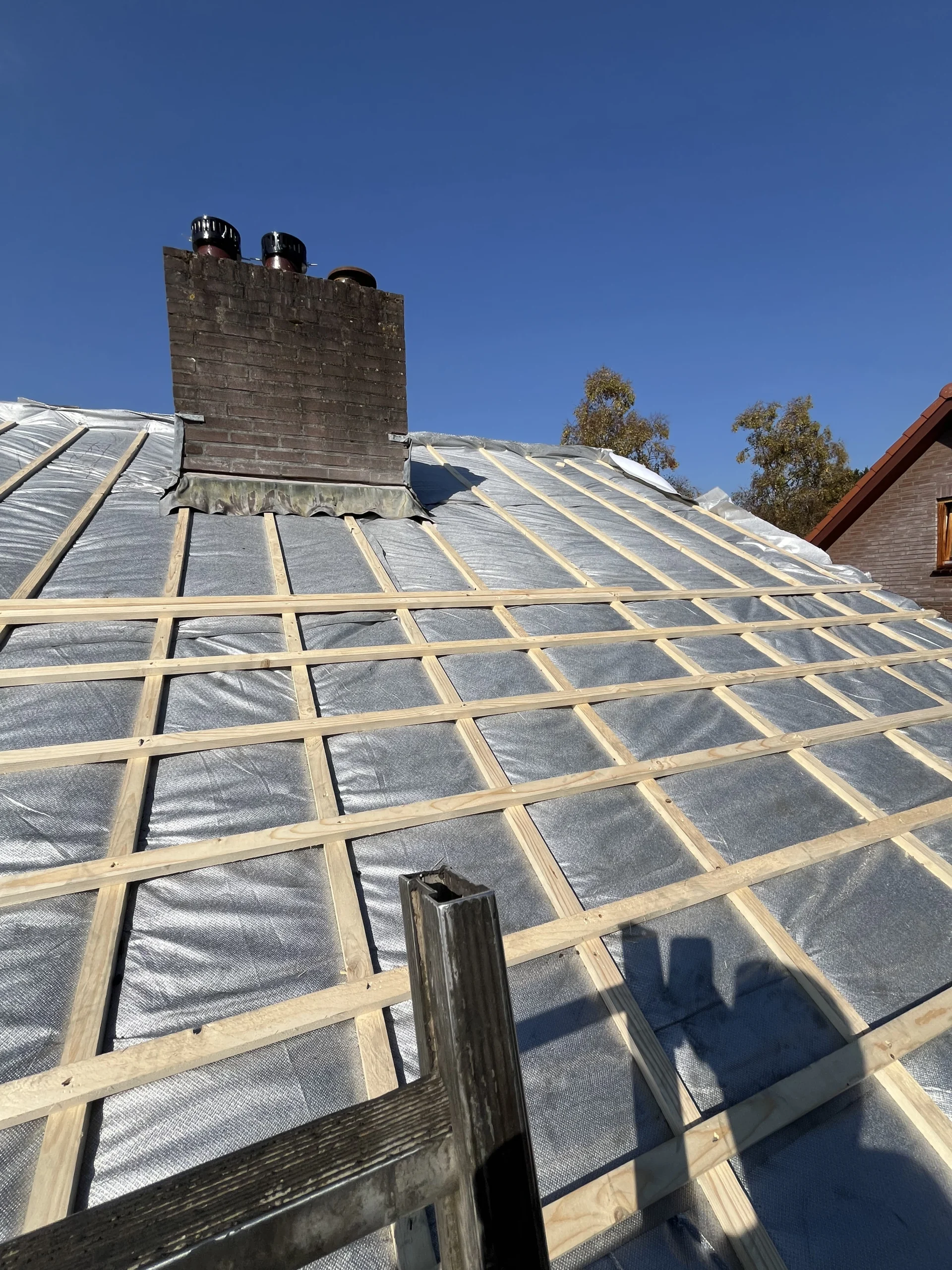 Dakrenovatie in uitvoering met nieuwe isolatie en lattenwerk door De Dakdekker Den Haag.