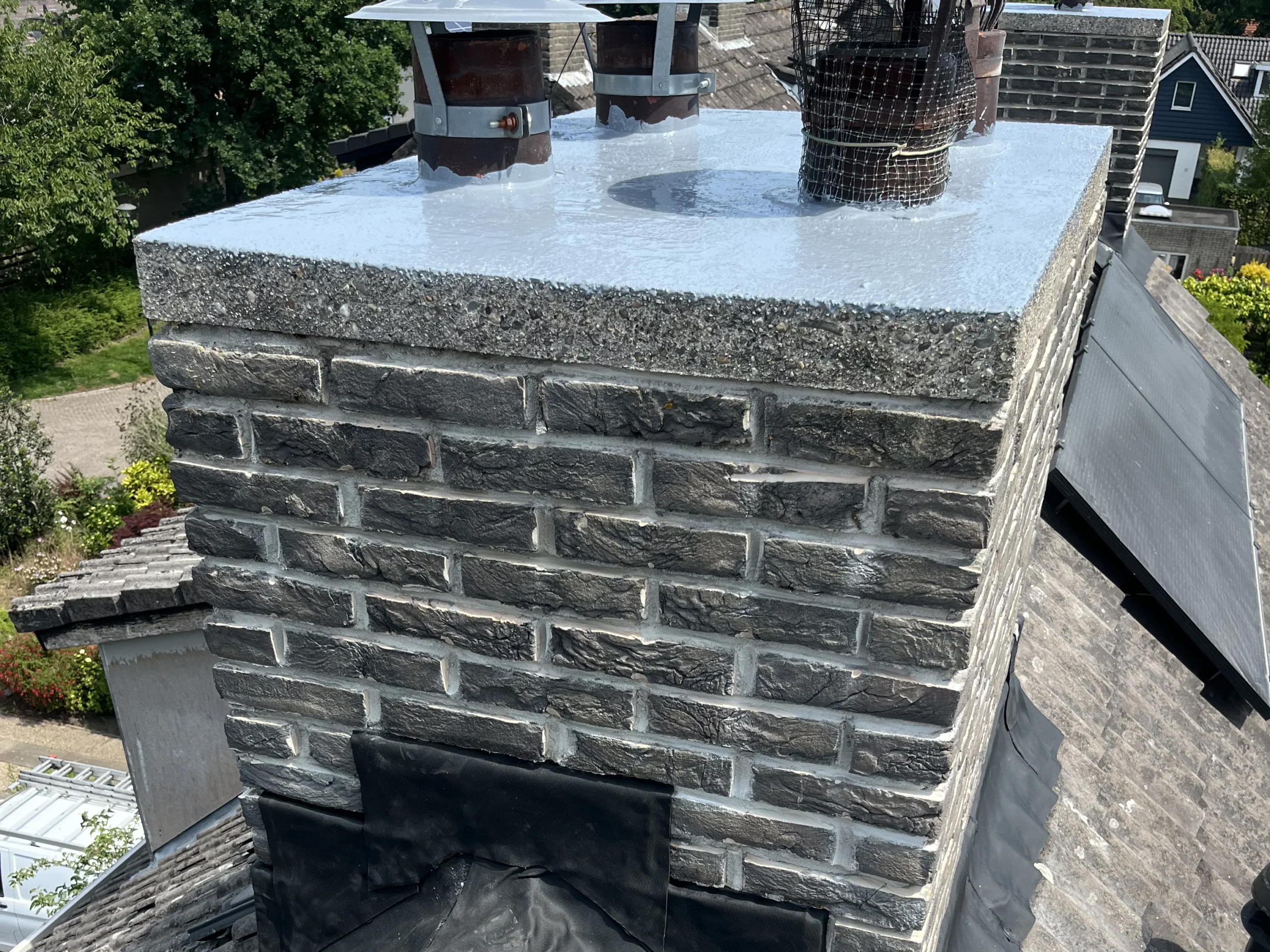 Vakkundige schoorsteenrenovatie in Den Haag door De Dakdekker Den Haag met nieuw loodwerk en hersteld metselwerk op een pannendak